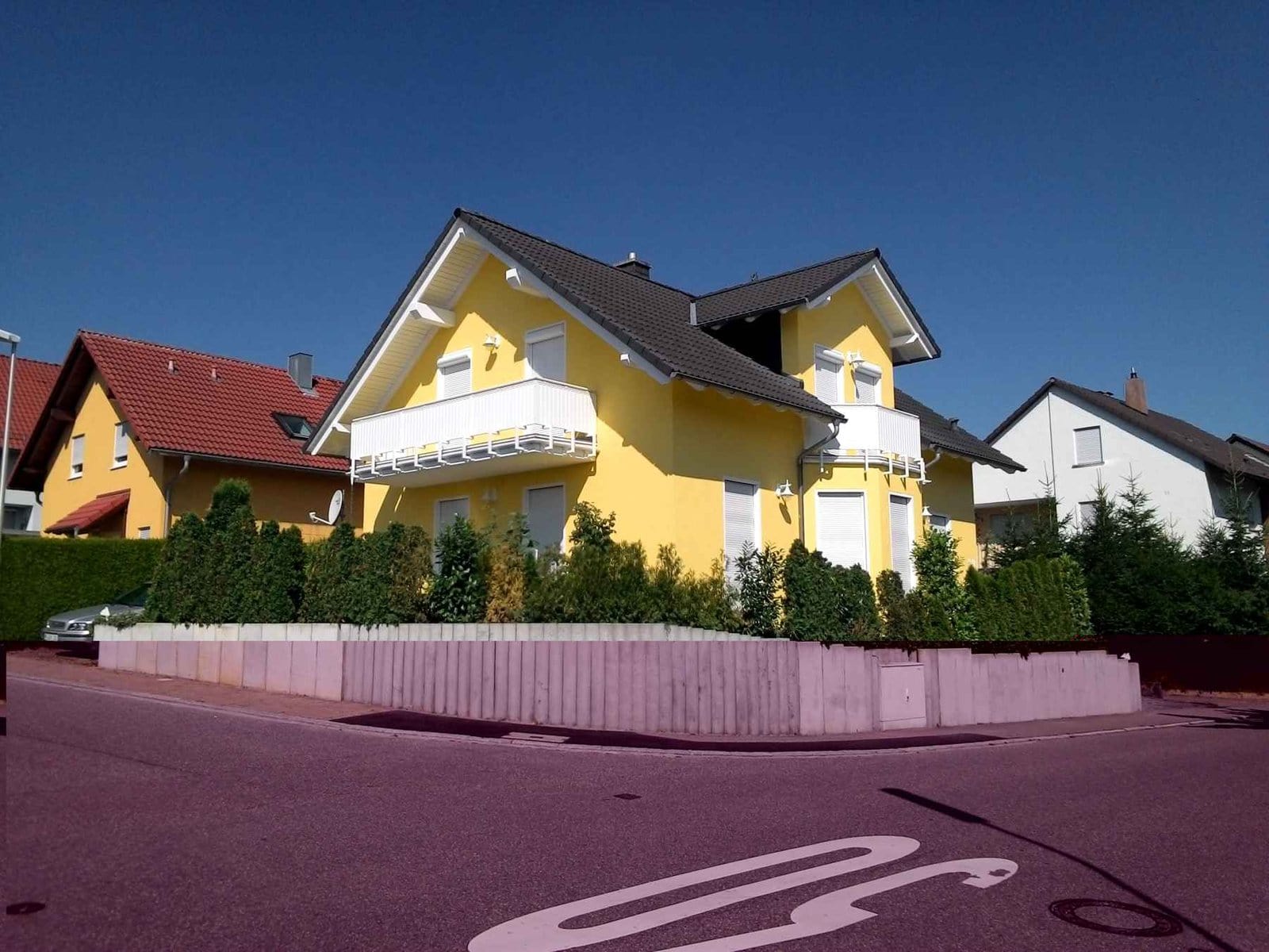 Gelbe Fassadengestaltung mit Putz und Anstrich an einem Mehrfamilienhaus.