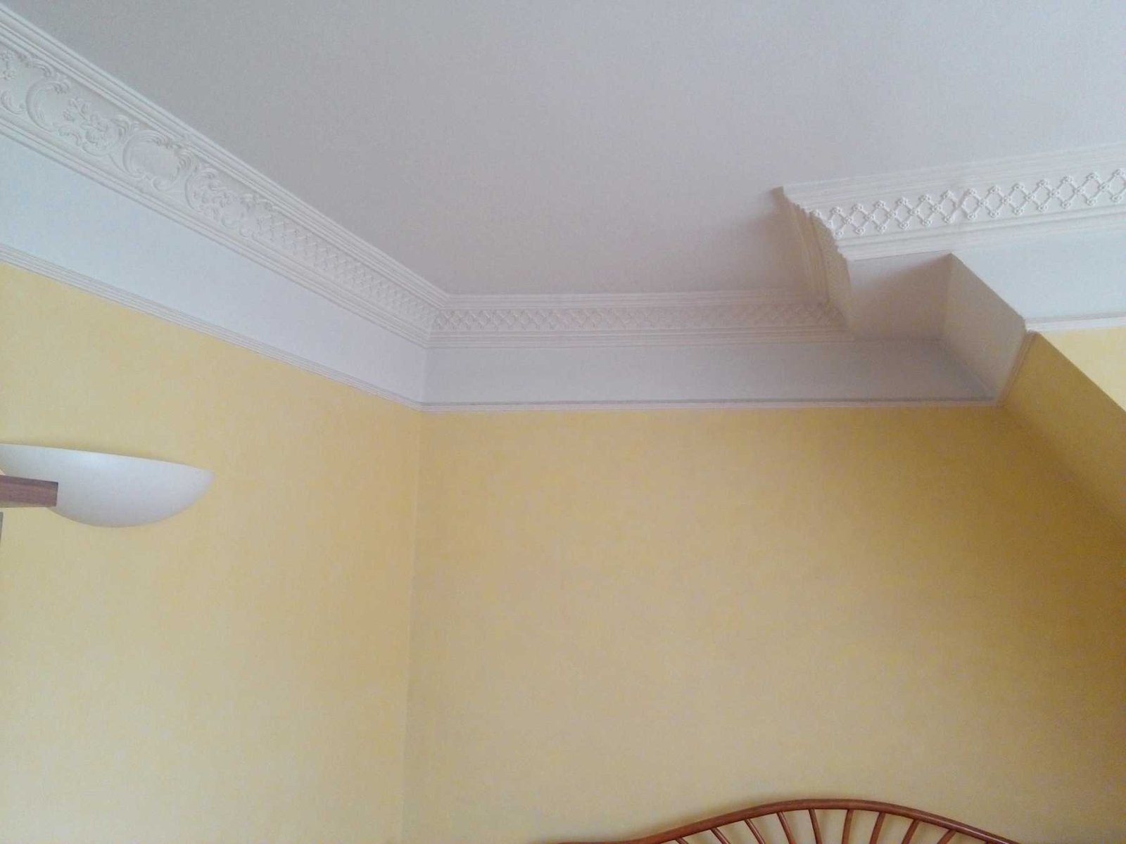 Dezente Stuckverzierung an Decke und Wand in hellem Raum.
