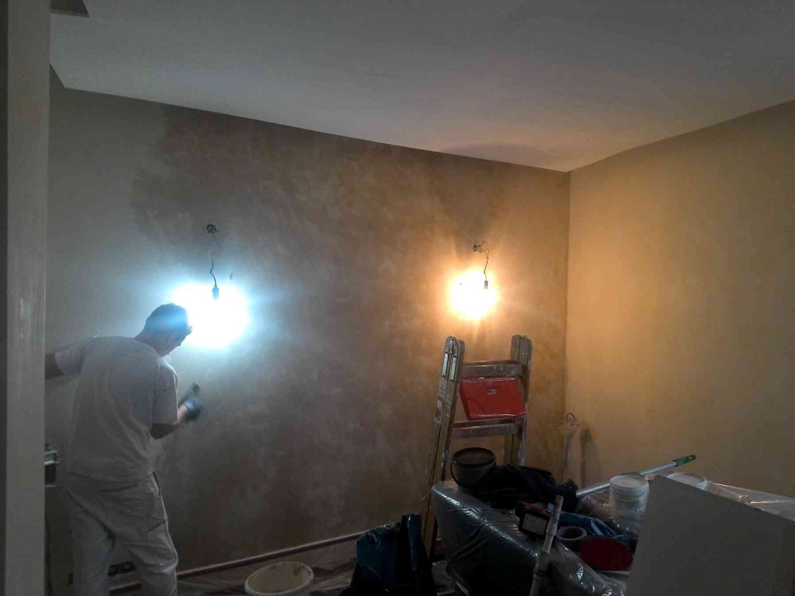Wand wird gestrichen, Handwerker arbeitet an der Wand.