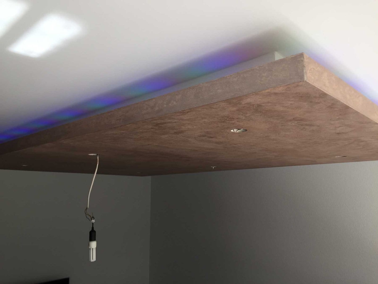 Unvollendete Deckenverkleidung aus Gipskarton mit Beleuchtungsinstallation.