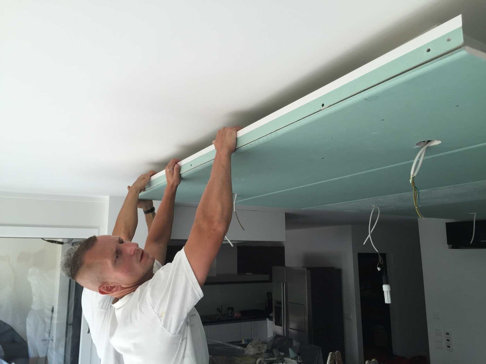 Maler montiert abgehängte Decke im Innenraum.